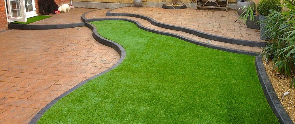 tiered garden featured with artificial grass and stone paving in South Wales